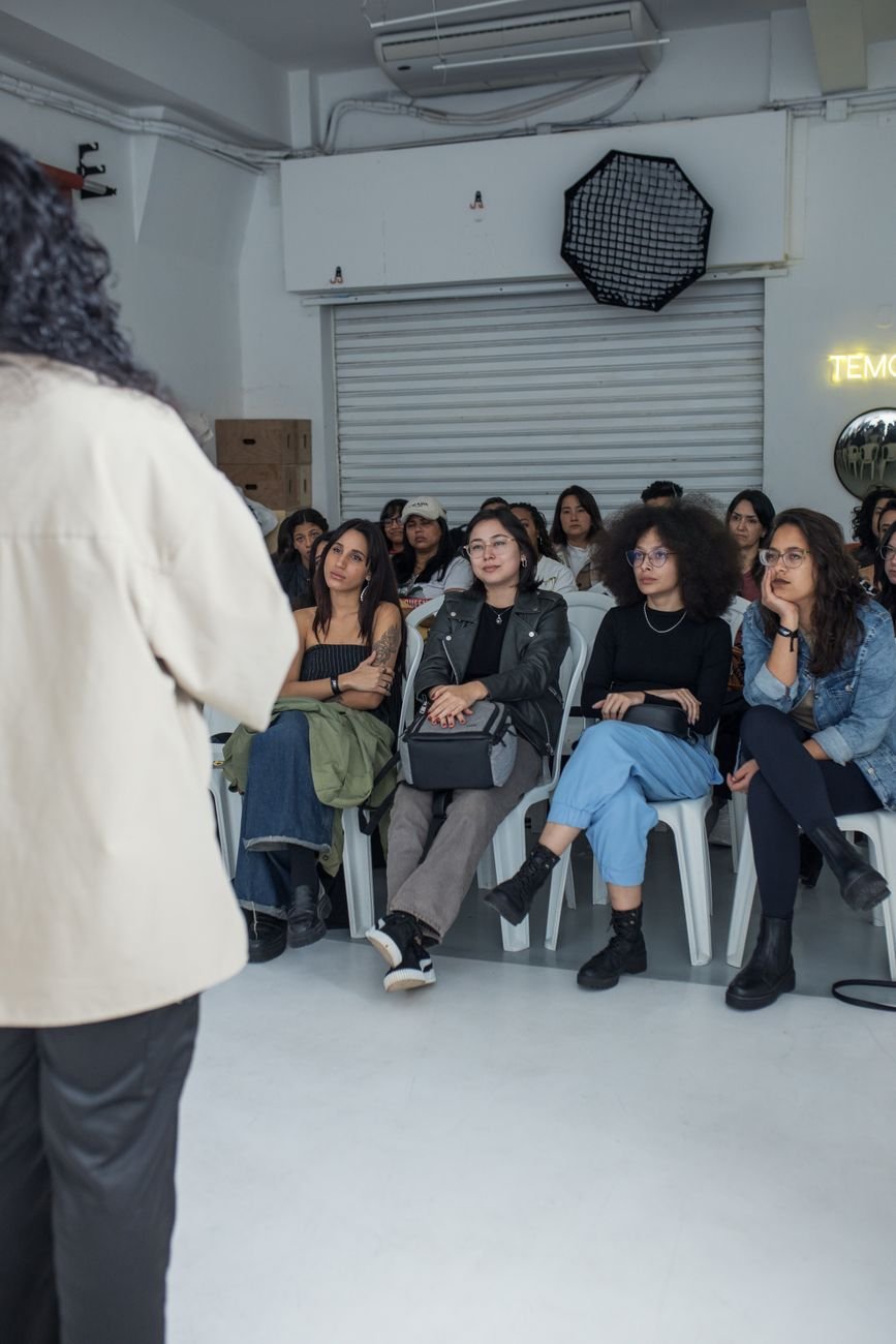 A diverse group of people attentively listening to a speaker at an indoor lecture.